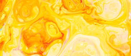 Fluid Art. Abstract blurred colorful background. Swirl liquid pattern. Marble effect of yellow red color. Trendy colorful backdropの写真素材