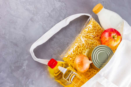 Food donations in linen bag. Food delivery in eco bag. Eco bag with food supplies food stock. Top view. Copy spaceの写真素材
