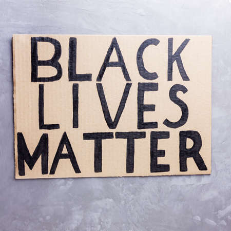 BLACK LIVES MATTER. No racism concept on a gray background. Cardboard banner with a text "Black Lives Matter". Concept of the struggle for equality. Copy spaceの写真素材