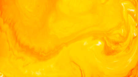 Fluid Art. Abstract blurred colorful background. Swirl liquid pattern. Marble effect of orange color. Trendy colorful backdrop. Mixing paintsの写真素材