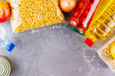 Food donations on a gray background. Food supplies. Coronavirus and quarantine concept. Top view....