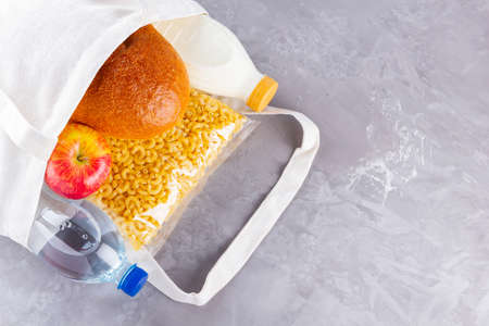 Food donations in linen bag. Food delivery in eco bag. Eco bag with food supplies food stock. Top view. Copy spaceの写真素材