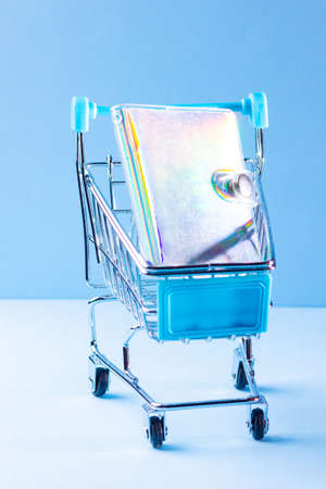 Shopping cart with school supply. School notepad with holographic cover. Purchase of school supplies for training. Back to school conceptの写真素材