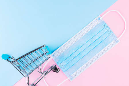 Shopping cart with protective medical mask. Safe shopping in the supermarket. Quarantine concept....