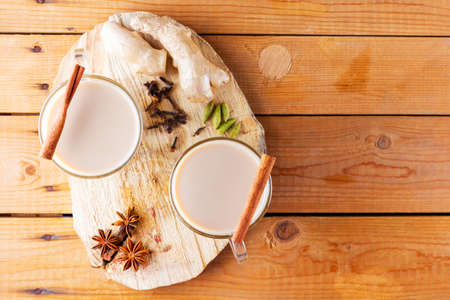 Masala chai tea on wooden stand. Traditional indian drink - masala tea with spices on a wooden background. Copy space. Top viewの写真素材