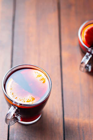 Mulled wine on wooden background. Winter drink traditional for the Christmas holidays. Two glasses of Christmas mulled wine with orangesの写真素材