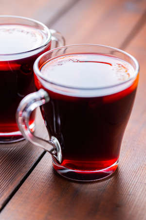 Mulled wine on wooden background. Winter drink traditional for the Christmas holidays. Two glasses of Christmas mulled wine with orangesの写真素材