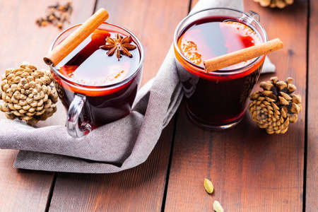 Mulled wine and honey on a wooden background. Two cups of autumn mulled wine and spices. Christmas hot drink in rustic styleの写真素材