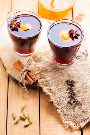 Mulled wine on a wooden background. Autumn mulled wine and spices on burlap. Christmas hot drink in rustic styleの写真素材