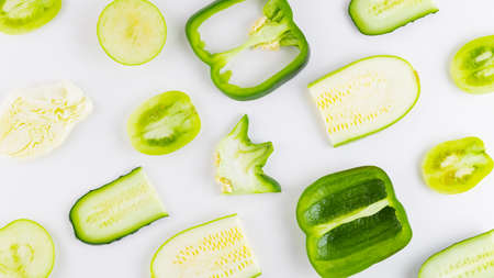 Collection of green vegetables and fruits on a white background. Vegetable pattern. Bell peppers, tomatoes, cucumber, cabbage, zucchini and apple for vegan. Top viewの写真素材