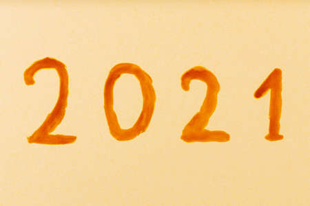 Text 2021 on a beige background. Concept of the New Year. Celebrating New Year in quarantine. Top...