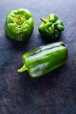 Ugly bell pepper on dark background. Deformed homegrown green bell pepper. Concept - reduction of food organic waste. Non GMO vegetables. Copy space. Top viewの写真素材
