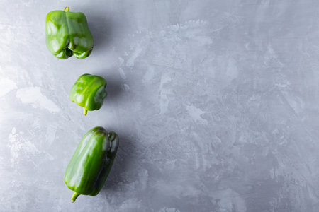 Ugly bell pepper on ultimate gray background. Deformed homegrown green bell pepper on the table. Concept - reduction of food organic waste. Non GMO vegetables. Copy space. Top viewの写真素材