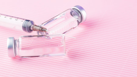 Healthcare cure concept with vaccine and syringe injection. Vaccines and syringe on a pink background for prevention and immunization. Copy space. Top viewの写真素材