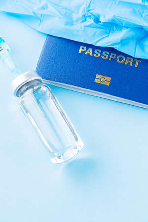Vaccination concept. International biometric vaccination passport, vaccine vial and syringe. Vaccine bottle, syringe and passport on a blue background. Immunity passportの写真素材