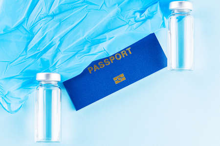 Vaccination concept. International biometric vaccination passport, vaccine vial and syringe. Vaccine bottle, syringe and passport on a blue background. Immunity passportの写真素材