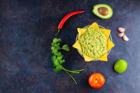 Guacamole with ingredients and nachos tortilla chips. Avocado guacamole with ingredients pepper,...