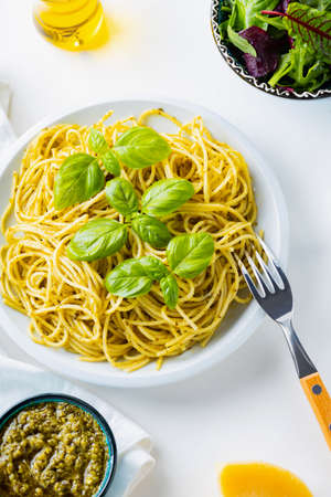 Spaghetti with pesto sauce and basil on a white background. Pasta with sauce pesto and ingredients. Traditional Italian cuisine. Food stylingの写真素材