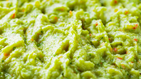 Guacamole close-up. Avocado guacamole sauce with fresh ingredients. Food background of guacamole sauceの写真素材