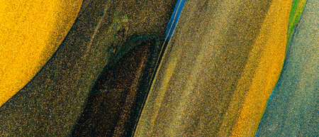 Abstract glitter background. Textured dark golden strokes. Gold glittering smear on a dark green...