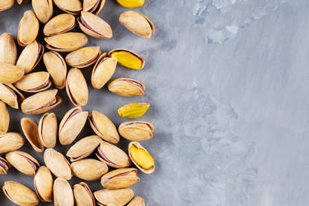 Pistachios nuts on a gray background. Roasted salted pistachios in shell. Concept of healthy eating vegan food. Copy space. Flat layの写真素材