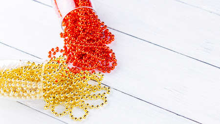 Champagne glasses with Christmas beads on white background. Christmas decorations on wooden boards. Copy space. Top viewの写真素材