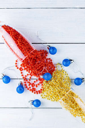 Two champagne glasses with Christmas beads on white background. Christmas balls and decorations on...