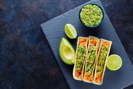 Mexican tacos with fried minced meat. Tacos with chicken and guacamole on a dark background. Mexican traditional cuisine. Copy space. Top viewの写真素材