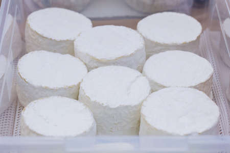 Camembert on counter in store. Basket of soft cheeses. Farmer camembert cheese on market counter. Close-upの写真素材