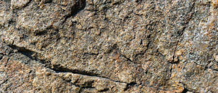 Granite rock texture. Cracked granite surface from weathering. Close-up of stone surface. Earth...