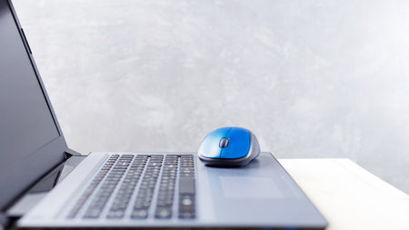 Open laptop and computer mouse on a wooden table. Comfortable workplace office for work or education in quarantine time. Home office concept. Copy spaceの写真素材