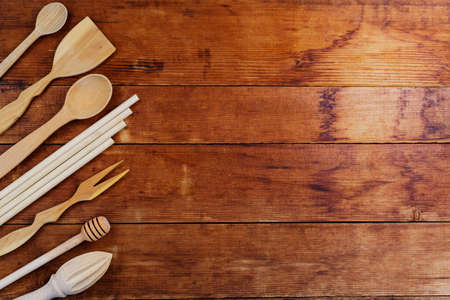 Set of wooden kitchenware on wooden table. Wooden cutlery on old planks. Eco-friendly tableware....