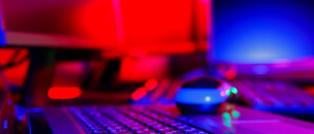 Creator's workplace in colored neon light. Computer equipment for creating visual content. Freelancer home office in pink blue light. Home office conceptの写真素材