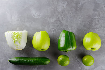 Different green vegetables and fruits on gray background. Healthy food concept. Top view. Copy spaceの写真素材