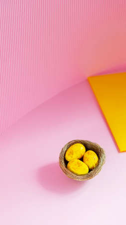 Easter eggs in a natural nest. Painted yellow golden eggs on a pink background. Easter minimalistic...