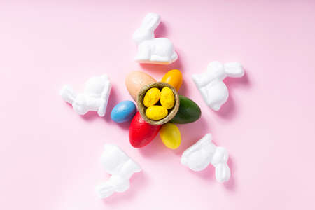 White rabbits and yellow Easter eggs on a pink background. easter decoration concept