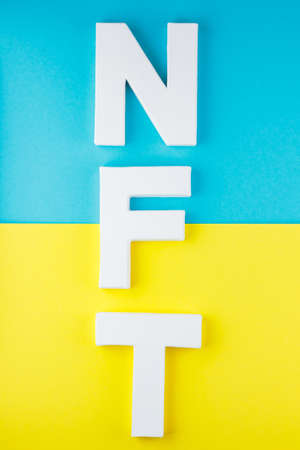 NFT inscription with white 3d letters on a blue-yellow background. Non-fungible token against...