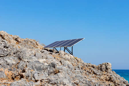 Solar panel (solar cell) on the rocky seashore. Source of alternative green solar energy. Concept...