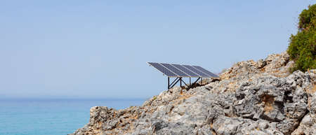 Solar panel (solar cell) on the rocky seashore. Source of alternative green solar energy. Concept clean energy power in nature. copy spaceの写真素材