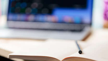 Home office with open laptop on blurred background. Notepad, pencil and laptop on a wooden table. Education business lifestyle concept. soft focus. copy spaceの写真素材