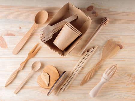 Various kitchen utensils on a wooden table. Set of the wooden cutlery and biodegradable cardboard paper cups. Eco-friendly sustainable lifestyle. Zero waste, plastic free conceptの写真素材