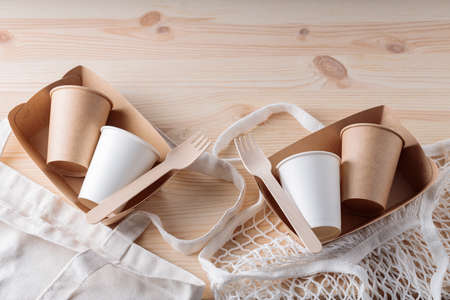 Wooden cutlery, paper disposable tableware and mesh bag. Eco friendly kitchen utensils and linen...