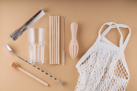 Cocktail spoon, ice tongs and glass for summer drink. Bamboo straws, cleaning brush and wooden...