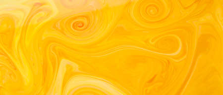 Abstract trendy golden orange backdrop. Yellow and orange paint pigment mix background. fluid artの写真素材