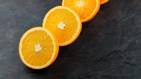 Halves of ripe oranges on a dark background. Sliced oranges for breakfast. copy space