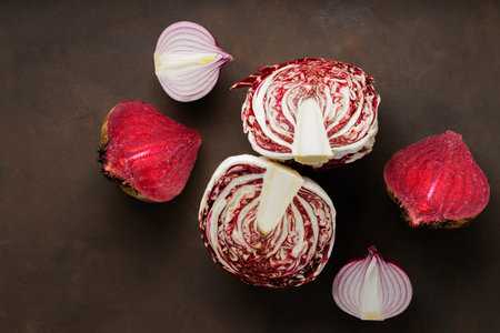 Purple vegetables on a dark background. Chopped beetroot, onion and radicchio salad for cooking. Creative still life with healthy purple vegetables. top viewの写真素材