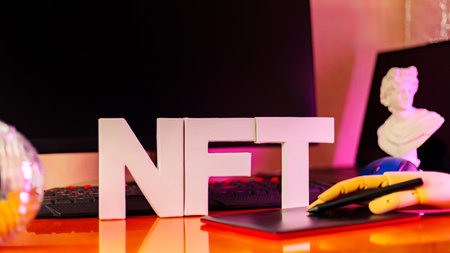 NFT inscription and artificial hand at the designer's workplace. Non-Fungible token lettering in neon light. Futuristic cryptocurrency conceptの写真素材