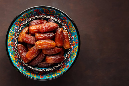 Dried dates in a bowl on a dark background. Bowl of pitted dates. Food for Ramadan. top view. copy spaceの写真素材