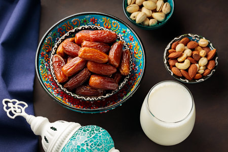 Dried dates, nuts and milk on a dark background. Ramadan Kareem and iftar muslim food and Turkish lamp. Ramadan concept. top viewの写真素材