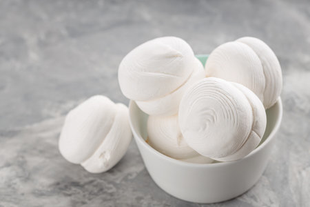 Marshmallows in a bowl on a gray background. Sweet dessert zephyr marshmallows on concrete. close upの写真素材